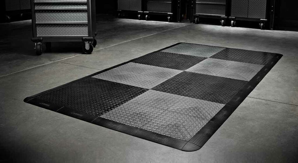 Area piastrellata con pavimento RaceDeck e delimitata con profili perimetrali per esposizione - Garage Mania